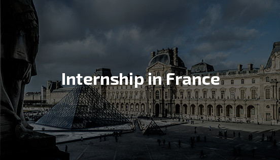 What it’s really like to apply for an internship in France The image shows the iconic courtyard of the Louvre Museum in Paris, France, featuring the glass pyramid in the center and the historic museum building in the background. The text "Internship in France" is prominently displayed in white over the image, suggesting opportunities to intern in France. The scene is set under a cloudy sky, with subtle lighting adding a dramatic atmosphere.
